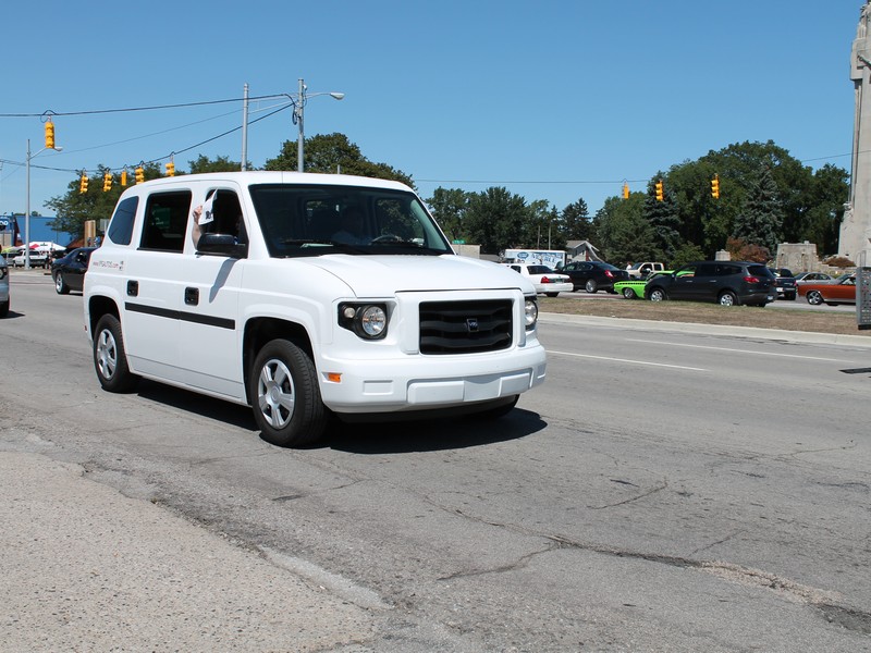 This is a new electric vehicle, not sure of the name.  But the side, back door, folds open for access for a wheelchair.  There is no front passenger seat so that the wheelchair rolls right in.  There are 3 seats across the back.  It is a neat looking vehicle.